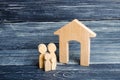 Young parents and a child are standing near their home. Concept of real estate, buying and selling a house. Affordable housing Royalty Free Stock Photo