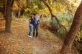 Young parents with a child in their arms walk along the path in the autumn Park Royalty Free Stock Photo