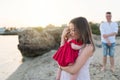 Young parents with cute baby girl outdoors on the beach, Royalty Free Stock Photo