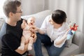 Young parents, father and mother, try to calm crying and tantrum of girl baby at home. Concept parenting Royalty Free Stock Photo