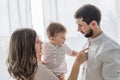 Young parents hold a baby in their arms and stand near the window in their new apartment. High quality photo Royalty Free Stock Photo