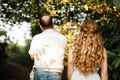 Young parents hugging each other and holding on the hands their little smiling daughter. Concept on family holidays and walking at Royalty Free Stock Photo