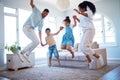 Young parents jumping and playing with their two children at home. Happy hispanic family having fun spending time Royalty Free Stock Photo