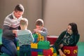 Young parents and kids having fun at childrens playroom