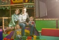 Young parents and kids having fun at childrens playroom