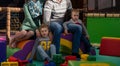 Young parents and kids having fun at childrens playroom