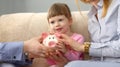 Young parents and little child girl are holding piggy bank Royalty Free Stock Photo