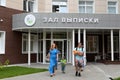 Young parents with a newborn baby come out of the discharge hall of the maternity hospital