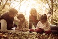 Parents in park with their daughters having education and teaching daughters to writing.