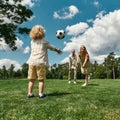 Young parents playing footabll with their little son on grass field in the park on a summer day Royalty Free Stock Photo