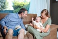 Young parents sitting on the sofa with their cheerful baby and a dog Royalty Free Stock Photo