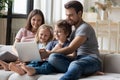 Young parents and small children watch laptop at home Royalty Free Stock Photo