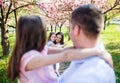 Young parents with small daugthers standing outside in spring nature. Royalty Free Stock Photo