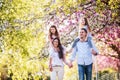 Young parents with small daugthers walking outside in spring nature. Royalty Free Stock Photo
