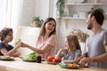 Young parents with small kids cooking together at home Royalty Free Stock Photo