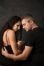 Young parents with their baby on a dark background, back view Royalty Free Stock Photo