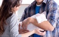 Young parents with their newborn baby near bed cot Royalty Free Stock Photo