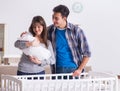 Young parents with their newborn baby near bed cot Royalty Free Stock Photo