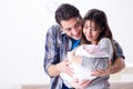 The young parents with their newborn baby near bed cot Royalty Free Stock Photo
