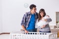 The young parents with their newborn baby near bed cot Royalty Free Stock Photo