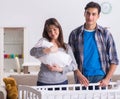 Young parents with their newborn baby near bed cot Royalty Free Stock Photo