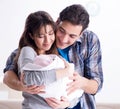 Young parents with their newborn baby near bed cot Royalty Free Stock Photo