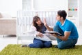 The young parents with their newborn baby sitting on the carpet Royalty Free Stock Photo