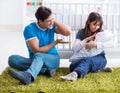 Young parents with their newborn baby sitting on the carpet Royalty Free Stock Photo