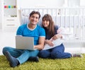 Young parents with their newborn baby sitting on the carpet Royalty Free Stock Photo