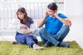 The young parents with their newborn baby sitting on the carpet Royalty Free Stock Photo