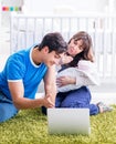 Young parents with their newborn baby sitting on the carpet Royalty Free Stock Photo