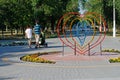 Young parents are walking next to an installation in the form of a heart in the park in Volgograd