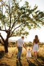 Young parents walking with their little daughter. in summer sunny park Concept on family holidays at nature, parenting and happy Royalty Free Stock Photo