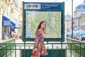 Young Parisian woman near the subway plan, looking for the direction Royalty Free Stock Photo