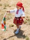 Young participant Festival Rozhen in national costume and the Bulgarian flag