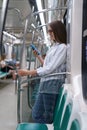 Passenger young woman using mobile smart phone chatting in social networks in subway train at metro Royalty Free Stock Photo