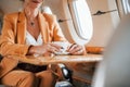 Young passenger woman in yellow clothes is flying in the plane