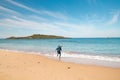 Young, passionate black-haired dobby runs from the waves of the Atlantic Ocean on a sandy beach near Porto Covo, Portugal