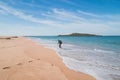 Young, passionate black-haired dobby runs from the waves of the Atlantic Ocean on a sandy beach near Porto Covo, Portugal. In the