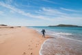 Young, passionate black-haired dobby runs from the waves of the Atlantic Ocean on a sandy beach near Porto Covo, Portugal. In the