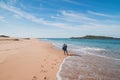 Young, passionate black-haired dobby runs from the waves of the Atlantic Ocean on a sandy beach near Porto Covo, Portugal. In the