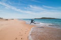 Young, passionate black-haired dobby runs from the waves of the Atlantic Ocean on a sandy beach near Porto Covo, Portugal. In the