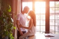 Young passionate couple in room against background window, girl is sitting