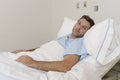 Young patient man lying at hospital bed resting tired looking sad and depressed worried Royalty Free Stock Photo