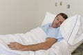 Young patient man lying at hospital bed resting tired looking sad and depressed worried Royalty Free Stock Photo