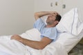 Young patient man lying at hospital bed resting tired looking sad and depressed worried Royalty Free Stock Photo