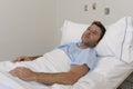 Young patient man lying at hospital bed resting tired looking sad and depressed worried