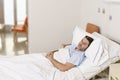 Young patient man lying at hospital bed resting tired looking sad and depressed worried Royalty Free Stock Photo