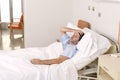 Young patient man lying at hospital bed resting tired looking sad and depressed worried Royalty Free Stock Photo