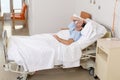 Young patient man lying at hospital bed resting tired looking sad and depressed worried Royalty Free Stock Photo